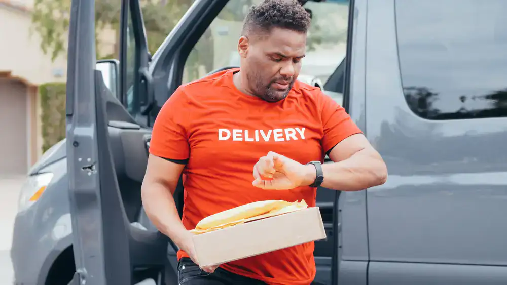 Courier looking at a smartwatch to check delivery timing