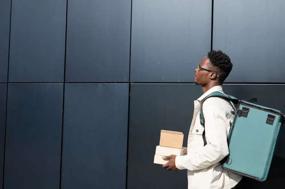 Courier placing parcel in bag